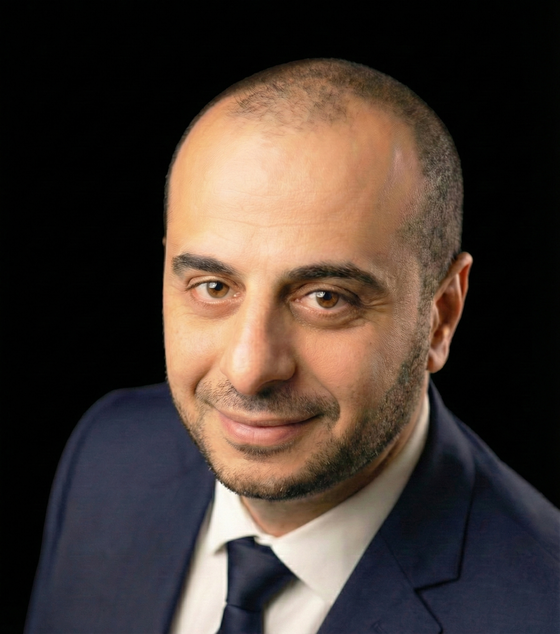 Professional headshot of man in navy blue suit and tie, updated hero section image with polished professional appearance maintaining The Vibe Inventor's futuristic aesthetic